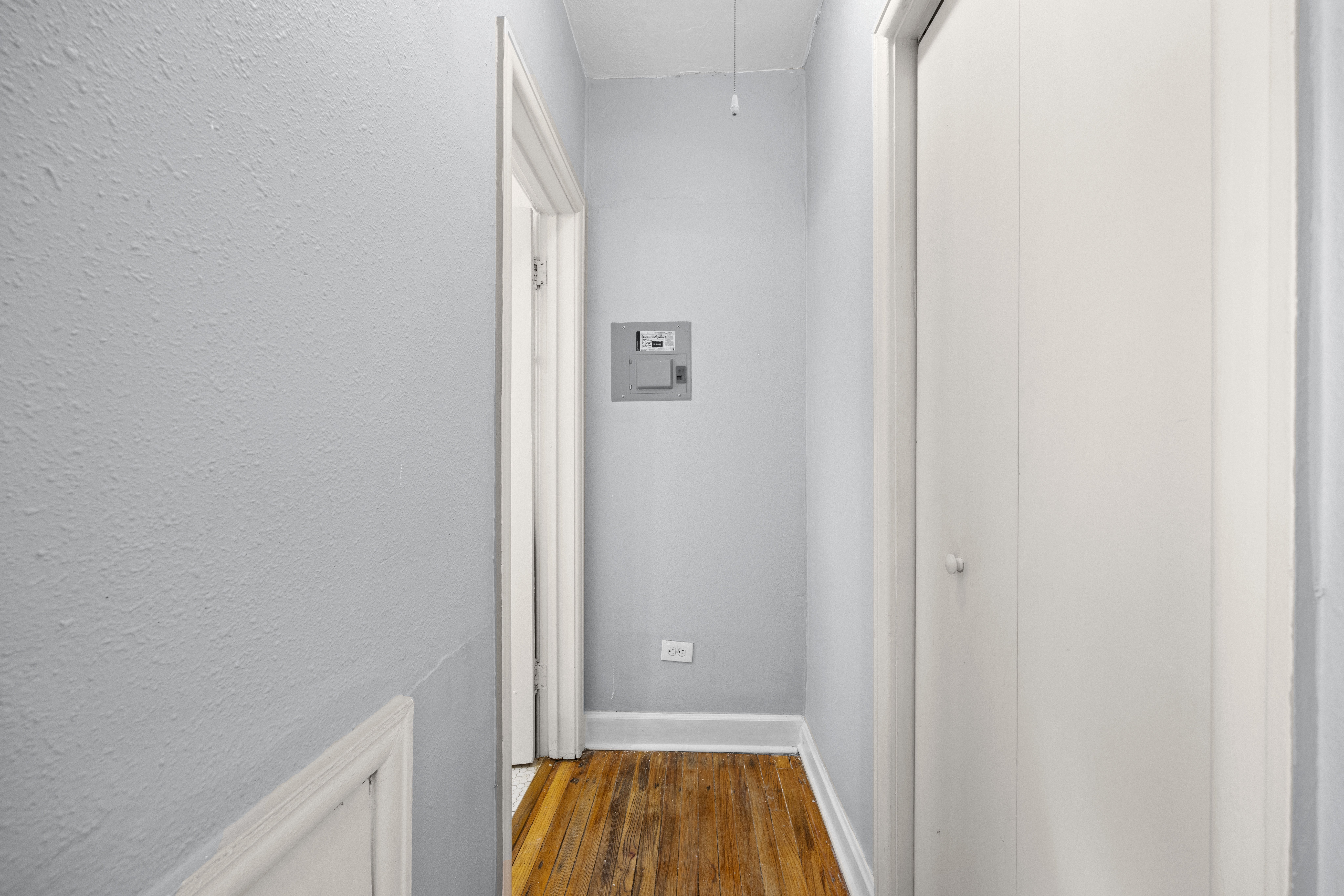 A room with a ceiling fan and wooden floors.